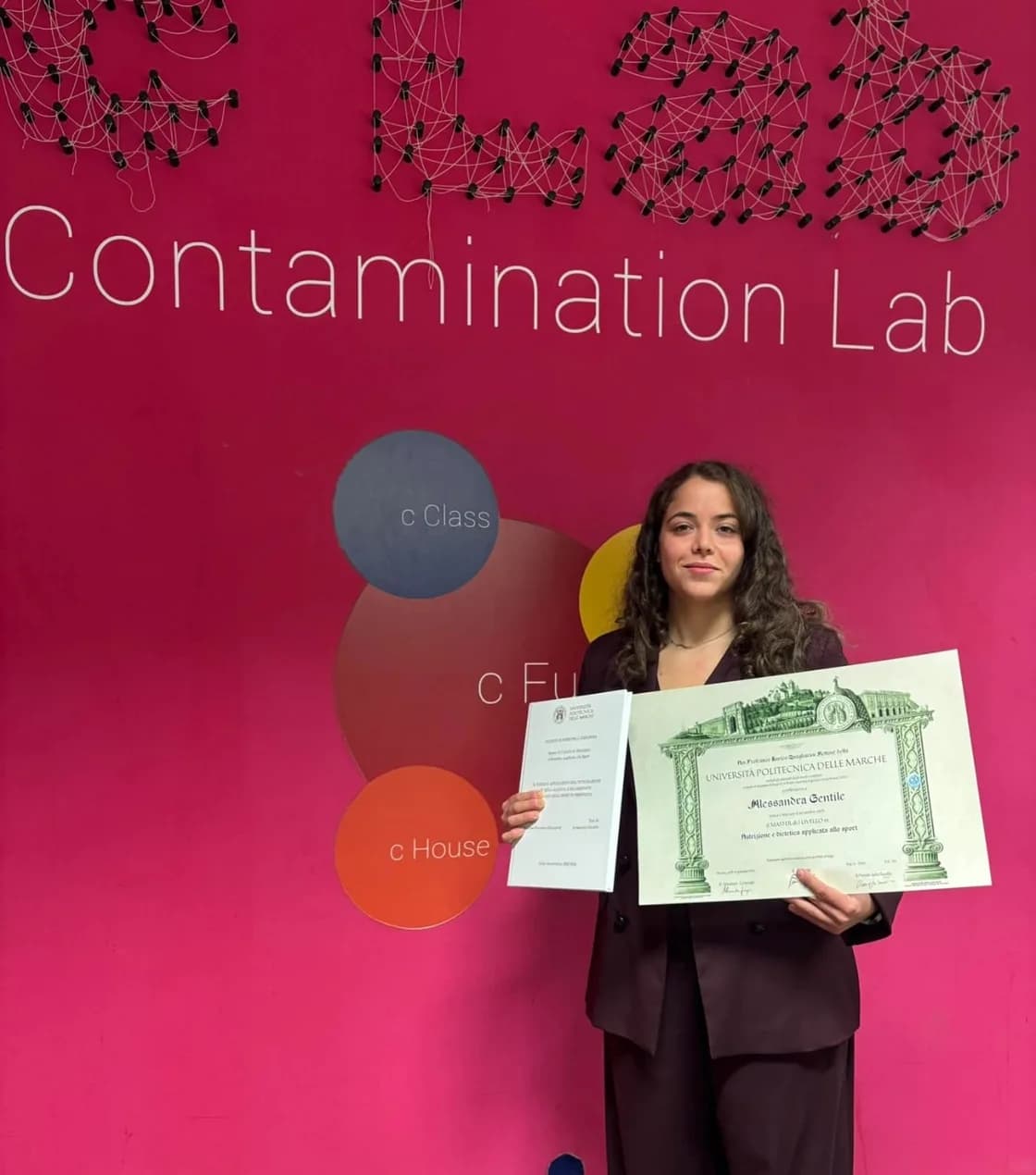 Alessandra Gentile con la tesi e il diploma del master in nutrizione e dietetica applicata allo sport